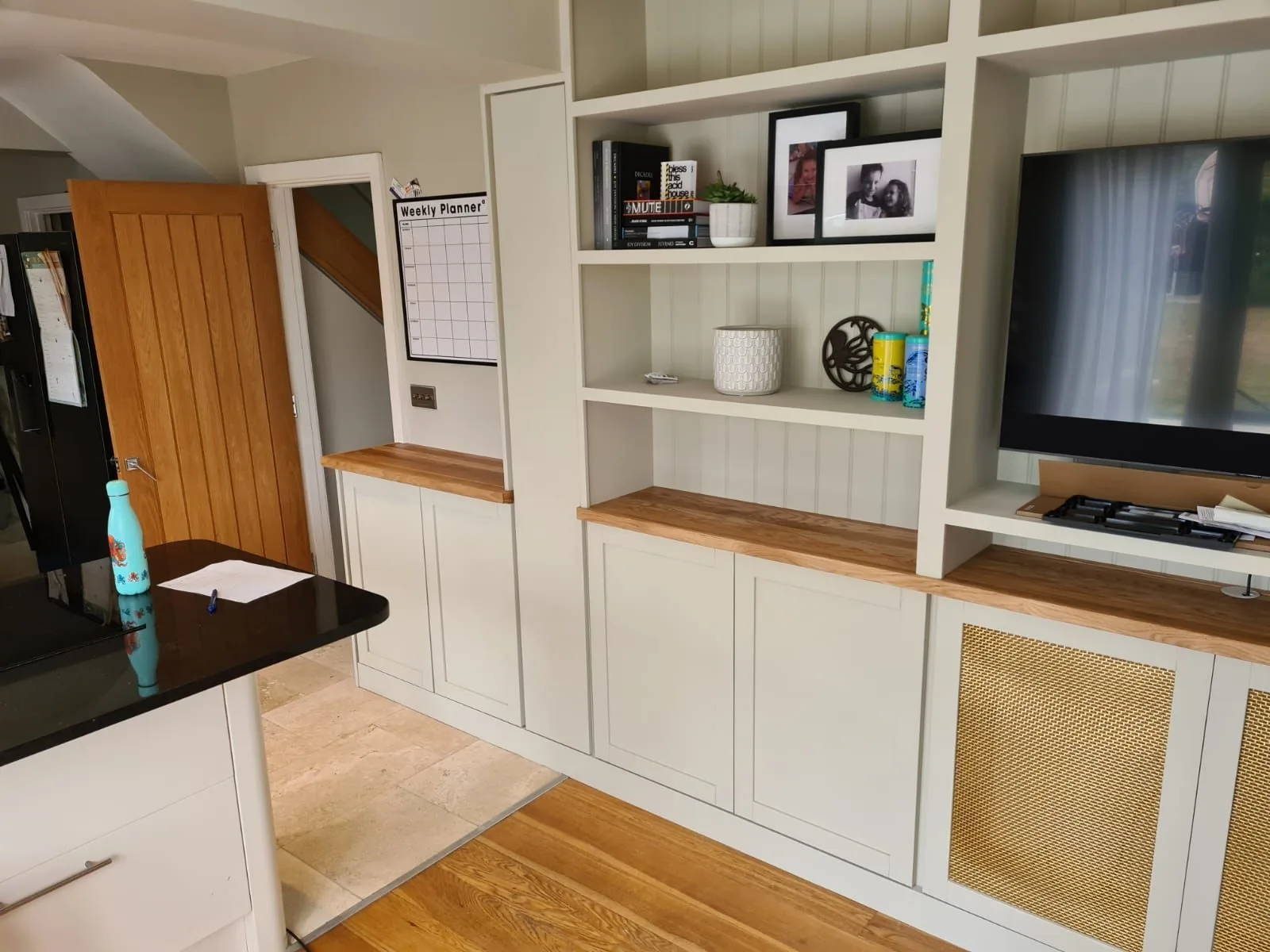 Media wall and fitted cabinetry flowing into the living space